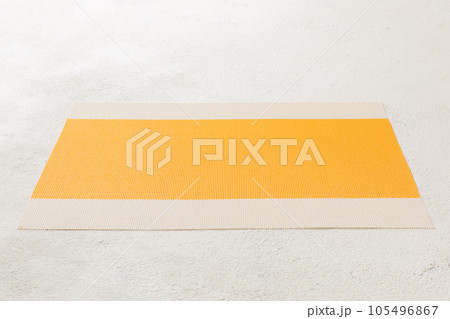 Perspective view of yellow tablecloth for food on cement background. Empty space for your design 105496867