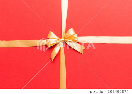 Top view of gold ribbon rolled and yellowbow isolated on colored background. Flat lay with copy space Top view of gold ribbon rolled and yellowbow isolated on colored background. Flat lay with copy space 105496874