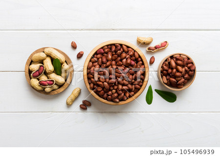 Fresh healthy peanuts in bowl on colored table background. Top view Healthy eating bertholletia concept. Super foods Fresh healthy peanuts in bowl on colored table background. Top view Healthy eating bertholletia concept. Super foods 105496939