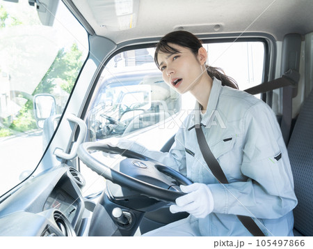 運転席に座る作業着を着た困った顔の若い女性トラックドライバー 運転席に座る作業着を着た困った顔の若い女性トラックドライバー 105497866