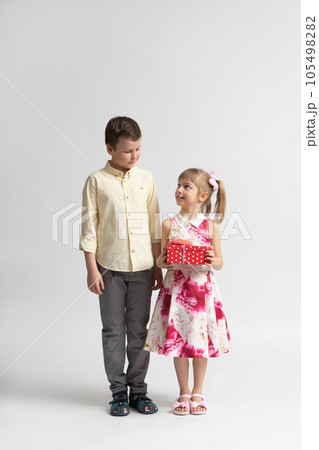 The younger girl gives a gift to the older boy - brother or friend. The younger girl gives a gift to the older boy - brother or friend. 105498282