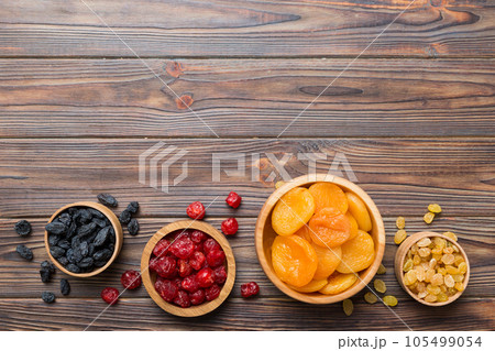 Bowl with different dried fruits on table background, top view. Healthy lifestyle with copy space 105499054