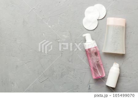 Micellar cleansing water and discs to remove cosmetics and cleanse the skin on colored background. Copy space top view Micellar cleansing water and discs to remove cosmetics and cleanse the skin on colored background. Copy space top view 105499070