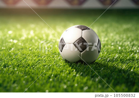Classic soccer ball in sunset with typical black and white pattern, placed on stadium turf. Traditional football ball on the green grass lawn with copy space. Classic soccer ball in sunset with typical black and white pattern, placed on stadium turf. Traditional football ball on the green grass lawn with copy space. 105500832