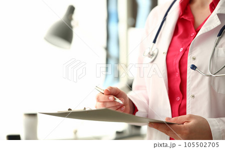 Medical doctor holds pen and a clipboard with documents 105502705