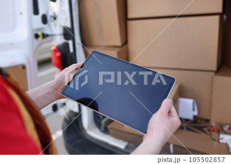 Courier looking for address on digital tablet Courier looking for address on digital tablet 105502857