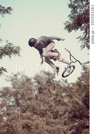 Young sportive man riding bmx bike outdoors, training, doing difficult and dangerous tricks with sport bike 105503261