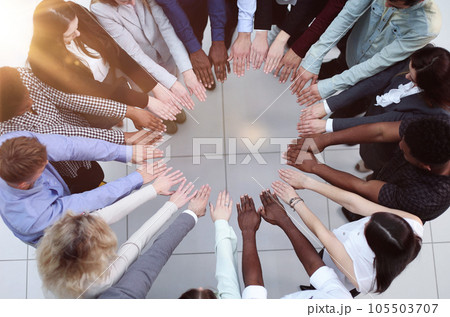 Friends with stack of hands showing unity and teamwork. 105503707