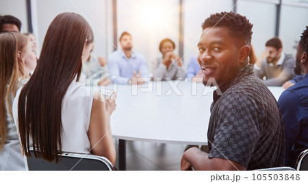 young African American man posing for the camera while sitting at a table 105503848