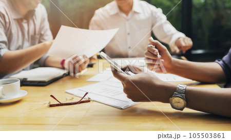 Businessman using smart phone while conference. Businessmen discussing together in meeting room. Business team meeting and discussing project plan. 105503861