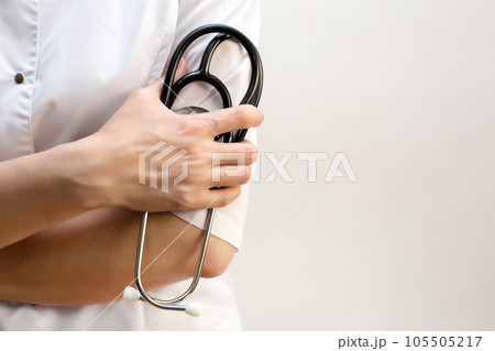 Medical stethoscope in the hands of a female doctor, close-up copy space 105505217