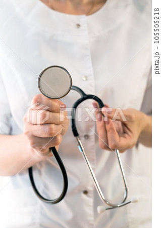 Medical stethoscope in the hands of a female doctor, close-up copy space 105505218