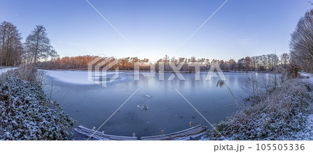 Panoramic image of frozen lake at frosty temperature during sunrise Panoramic image of frozen lake at frosty temperature during sunrise 105505336