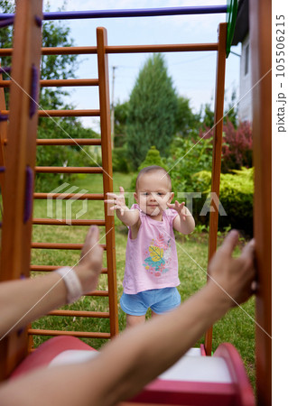 little baby girl with mother on slide in playground little baby girl with mother on slide in playground 105506215
