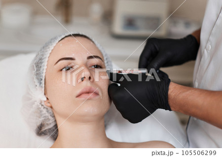 woman receives cosmetic botox injection in face. 105506299