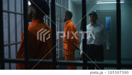 Criminals stand face to cell with hands behind Criminals stand face to cell with hands behind 105507390