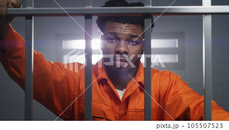 Inmate looks at camera and kneads neck 105507523
