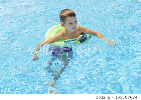 Child boy in swimming pool on inflatable rubber circle ring Child boy in swimming pool on inflatable rubber circle ring 105507624