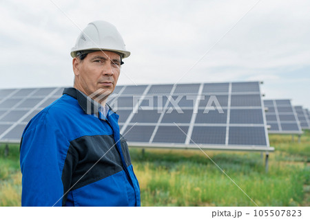 Service Engineer man standing in front of solar panels. Technician maintenance solar cells on Solar Energy Plant under morning sunlight. Technology solar energy renewable 105507823