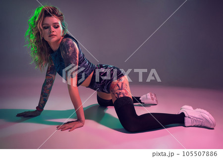 beautiful caucasian blonde girl in velour blue booty shorts and black stockings dancing twerk on her knees on pink background beautiful caucasian blonde girl in velour blue booty shorts and black stockings dancing twerk on her knees on pink background 105507886