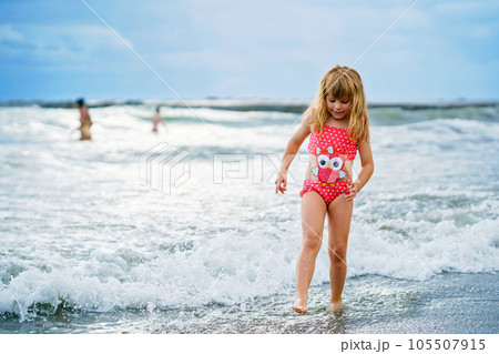 Happy Child, Little Preschool Girl in Swimmsuit Running And Jumping In The Waves During Summer Vacation On Exotic Tropical Beach. Family Journey On Ocean Coast. Happy Child, Little Preschool Girl in Swimmsuit Running And Jumping In The Waves During Summer Vacation On Exotic Tropical Beach. Family Journey On Ocean Coast. 105507915