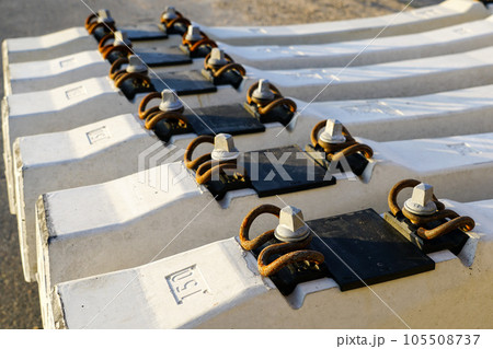 Before track repair stacked new white reinforced concrete railroad track sleepers with rail mounts Before track repair stacked new white reinforced concrete railroad track sleepers with rail mounts 105508737