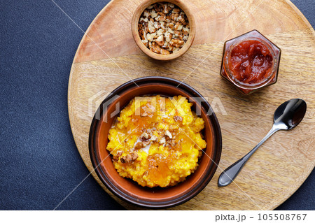 Sweet pumpkin porridge in clay bowl with jam and nuts Sweet pumpkin porridge in clay bowl with jam and nuts 105508767