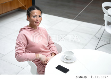 portrait of woman sitting at table in cafe 105508857