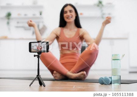 Female trainer shooting video about meditation indoors Female trainer shooting video about meditation indoors 105511388