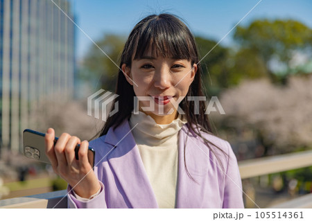 スマホを右手に持つ女性 105514361