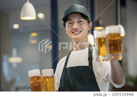 ビールのジョッキを持った若い男性　飲食店　ホールスタッフ　イメージ 105515948