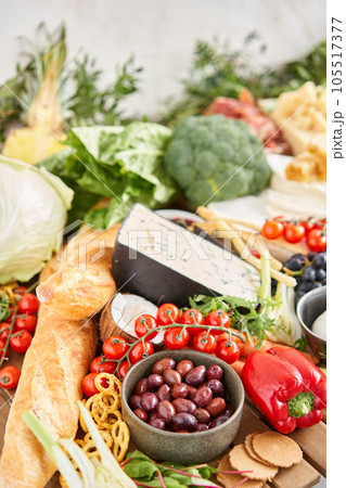 olives in the foreground.. Table full of mediterranean appetizers, tapas or antipasto. Assorted Italian food set. Delicious snack on party or picnic time. Meat and cheese. Italian style banquet.  105517377