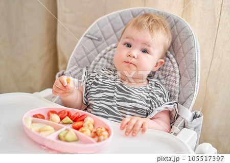 Cute child eats healthy food vegetables and meatballs from dietary meat steamed,. Portraits of a cute 10 months old baby girl. The baby sitting in a special high chair for babies. Cute child eats healthy food vegetables and meatballs from dietary meat steamed,. Portraits of a cute 10 months old baby girl. The baby sitting in a special high chair for babies. 105517397