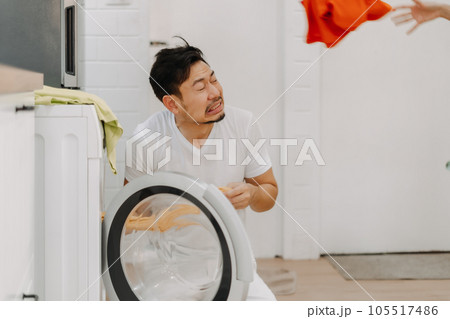Funny couple. Wife teaching husband to do laundry on washing machine. Funny couple. Wife teaching husband to do laundry on washing machine. 105517486