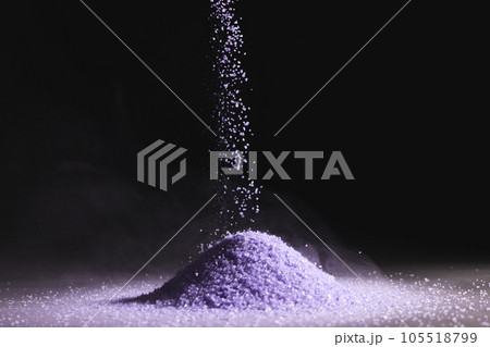 Close up of purple sand thrown in the air and copy space on black background 105518799