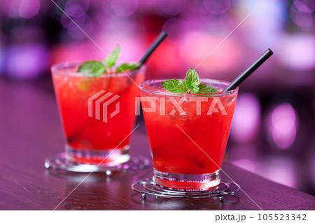 Two Mai Tai cocktail shot on a bar counter in a nightclub. Vertical shot Two Mai Tai cocktail shot on a bar counter in a nightclub. Vertical shot 105523342