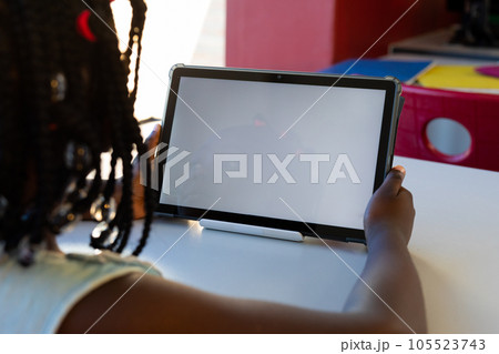 Rear view of african american school girl using digital tablet with copy space at elementary school 105523743