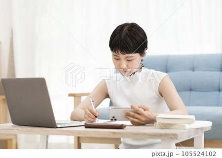 スマホを使い勉強をする若い女性 大学生　高校生 105524102
