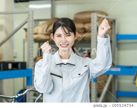 物流センターの倉庫でガッツポーズをして立つ若い女性スタッフ 105524734