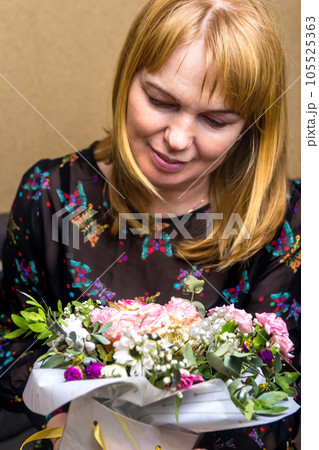 Defocus Woman flowers. A woman admires a gorgeous bouquet. The blonde looks at a beautiful flower arrangement Congratulations on Women's Day, Mother's Day, Birthday Vertical photography. Out of focus Defocus Woman flowers. A woman admires a gorgeous bouquet. The blonde looks at a beautiful flower arrangement Congratulations on Women's Day, Mother's Day, Birthday Vertical photography. Out of focus 105525363