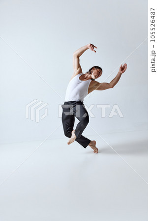 Handsome man with muscular body posing in motion against grey studio background. Strong, relief body Handsome man with muscular body posing in motion against grey studio background. Strong, relief body 105526487
