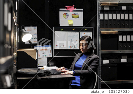 Accountant businesswoman employee unpacking laptop in office suitcase bag starting shiftwork. Bookkeeping executive in archival depository filled with cabinet, folders and flowcharts 105527039