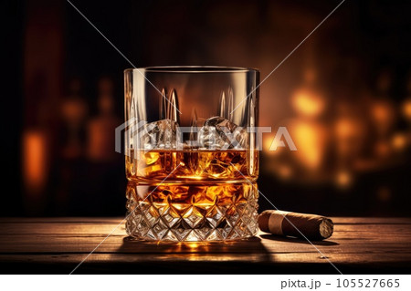 Whiskey glass and cigar on wooden table Whiskey glass and cigar on wooden table 105527665