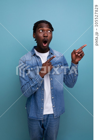 charismatic stylish african man with black dreadlocks points finger to the side charismatic stylish african man with black dreadlocks points finger to the side 105527829