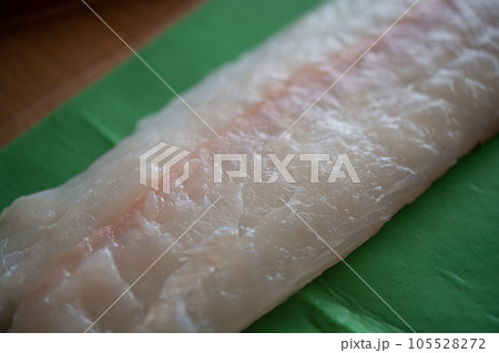 天然ヒラメの柵をドリップシートで包む 105528272