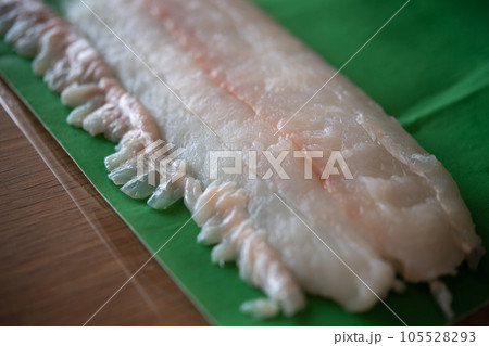 天然ヒラメのサクと縁側をドリップシートで包む 105528293