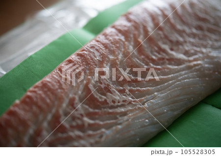 天然ヒラメの柵をドリップシートで包む 105528305