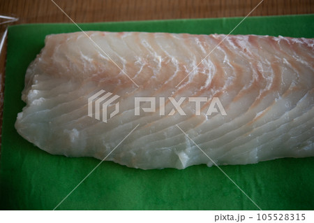 天然ヒラメの柵をドリップシートで包む 105528315