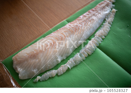 天然ヒラメの柵をドリップシートで包む 105528327