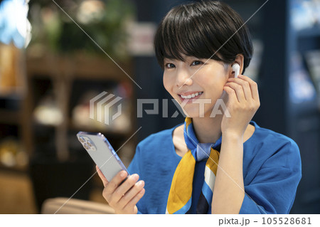 イヤホンをつけてスマートフォンを持った若い女性 撮影協力:Creadisce(丸善雄松堂株式会社) イヤホンをつけてスマートフォンを持った若い女性 撮影協力:Creadisce(丸善雄松堂株式会社) 105528681